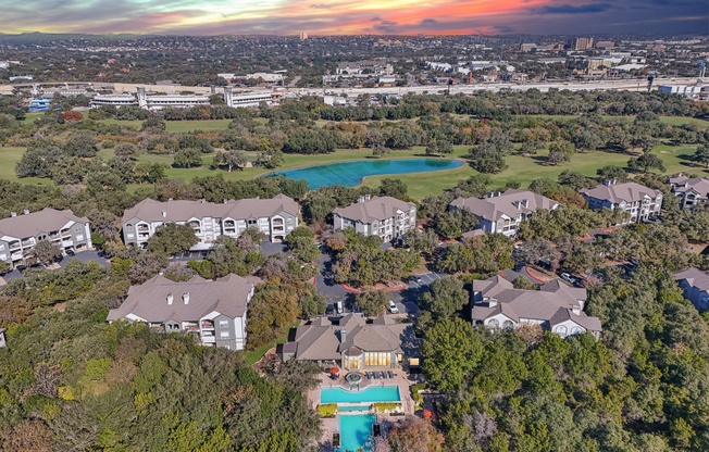A bird's eye view of a residential area with houses and a swimming pool.