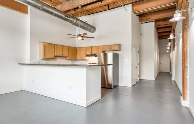 a kitchen with white walls and wood cabinets