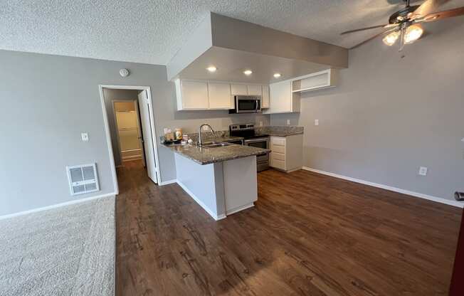 the view of a kitchen and living room from the entryway of an empty house