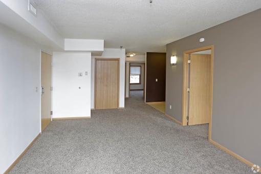 an empty room with white walls and grey carpet at Kassenborg, Moorhead, Minnesota