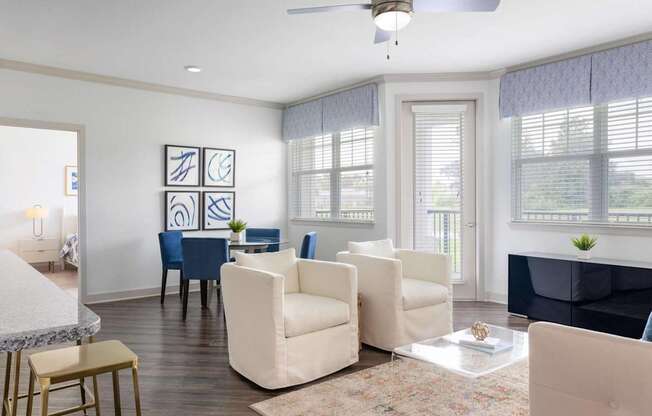 A living room with a white ceiling fan and a rug on the floor.