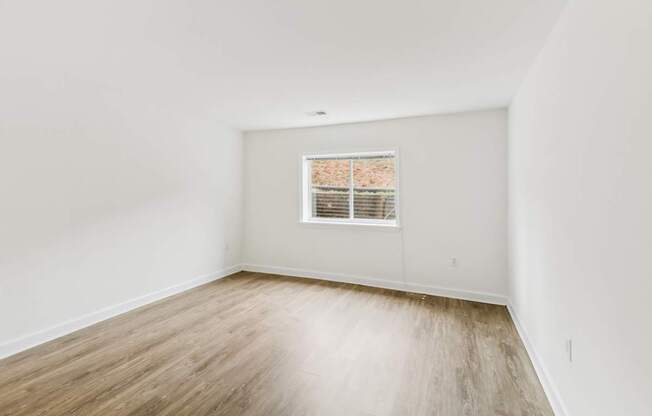 an empty room with white walls and a window