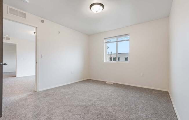 A room with a carpeted floor and a window.