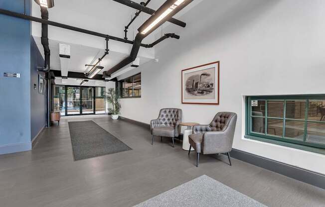 A room with a grey sofa and a brown armchair.