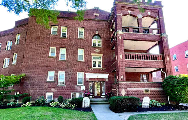 A red brick building with a green tree on top.