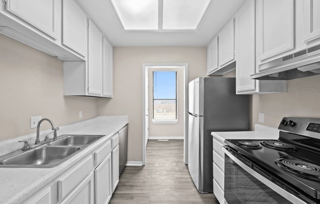 a kitchen with white cabinets and stainless steel appliances and a window at Diamond Ridge Townhomes, Oklahoma City Oklahoma
