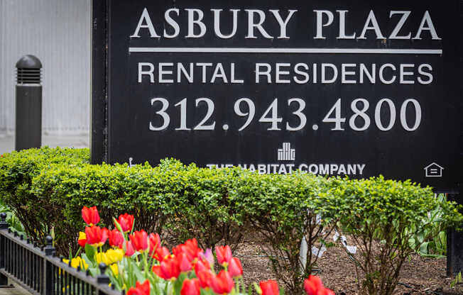 A sign for Asbury Plaza Rental Residences with a phone number and a small house icon.