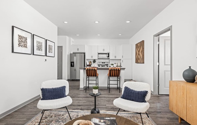 a living room with three chairs and a kitchen in the background