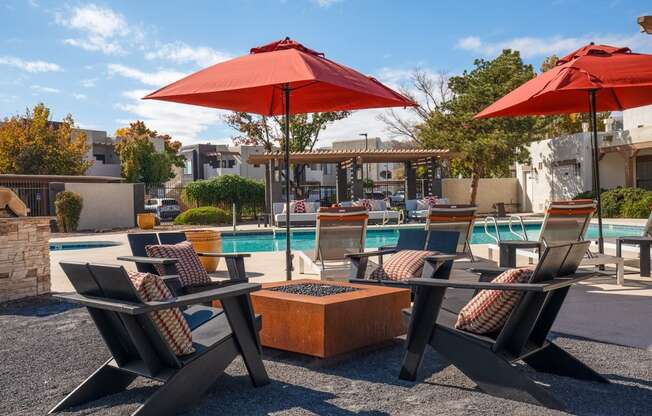 a swimming pool with chairs and umbrellas and a poolside table with chairs