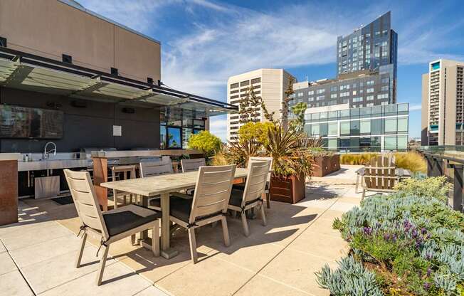 A patio with a table and chairs overlooks a cityscape.
