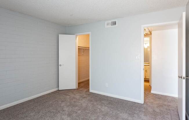 A room with a white door and a carpeted floor.