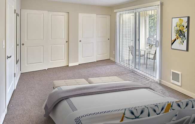 Large, carpeted primary bedroom with two sliding door closets along far wall. Sliding glass door to out door balcony. Bedroom fits a king sized bed. at 3030 Lake City, Seattle, Washington