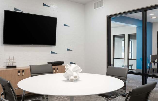 A white table with a vase on it and chairs around it.