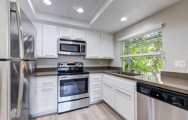 a kitchen with white cabinets and stainless steel appliances