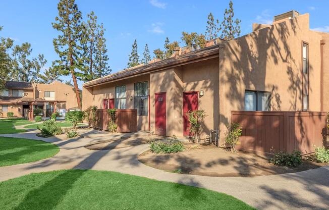 a large brick building with grass in front of a house