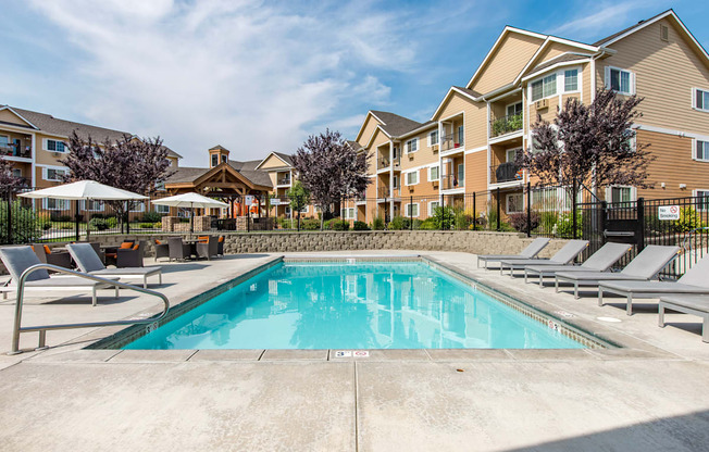 our apartments have a swimming pool with chairs and umbrellas. apartments with a pool at Quail Springs Apartments