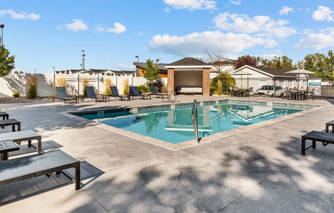 Swimming Pool with lounge seating surrounding perimeter at Eagles Landing, Ammon, Idaho