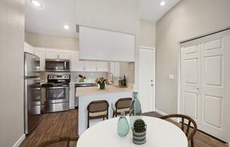 an open kitchen and dining room with stainless steel appliances and a white table