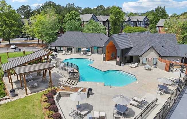 A large outdoor swimming pool surrounded by lounge chairs and umbrellas.