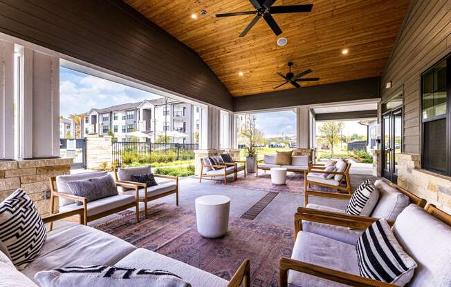 Covered patio with couches and chairs and a tv at The Parker Austin, Texas
