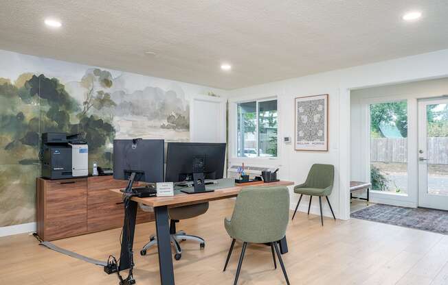 A room with a desk, chairs, and a computer setup.