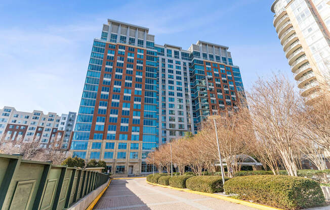 an empty sidewalk in front of a tall building