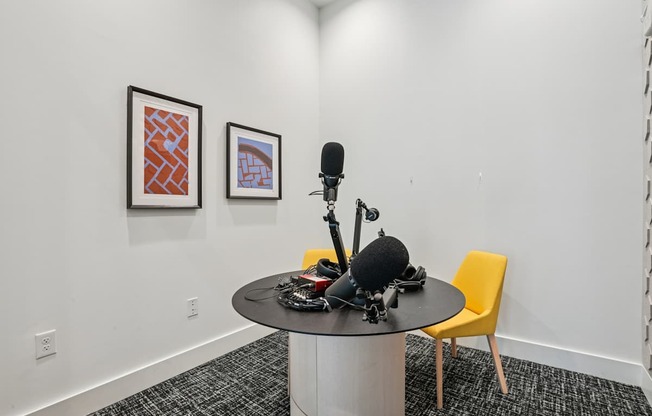 A room with a table, a microphone and a chair.
