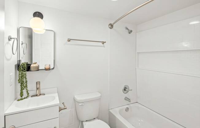 a white bathroom with a white toilet and a tub and a sink at The Courts Midtown, Memphis, TN, 38104