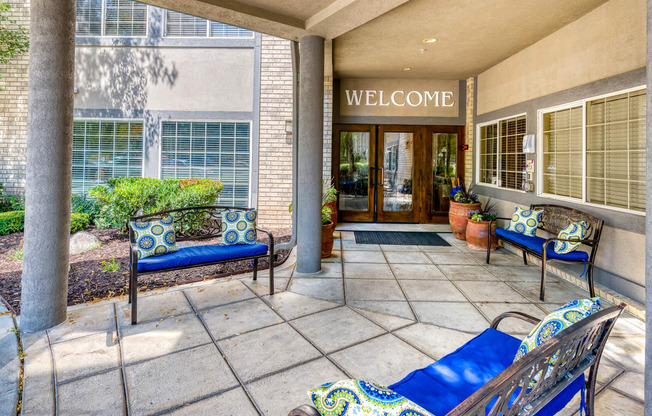 a patio with blue furniture and potted plants