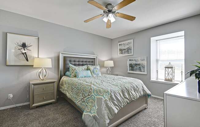 carpeted bedroom with ceiling fan and huge window