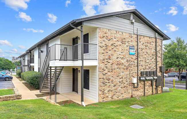A small brick building with a balcony and a sign on the front.
