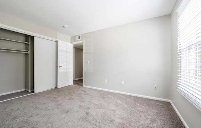 A room with a grey carpet and white walls.