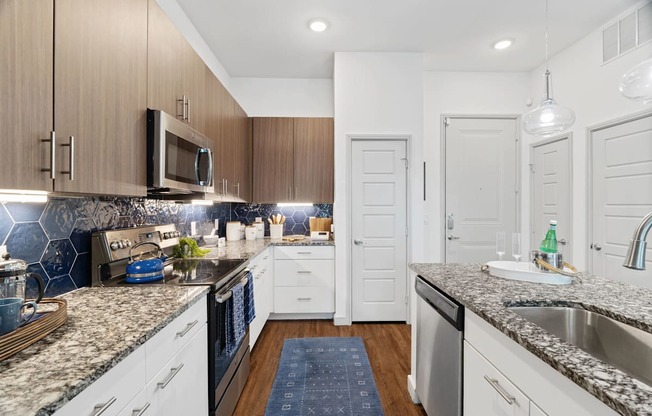 A kitchen with white cabinets and a granite countertop.