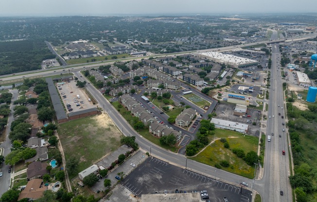 an aerial view of a city with an intersection with cars and buildings