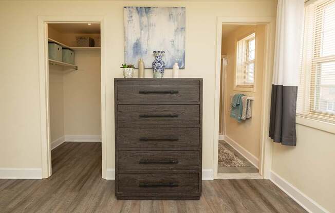 A large wooden chest of drawers is in the corner of a room.