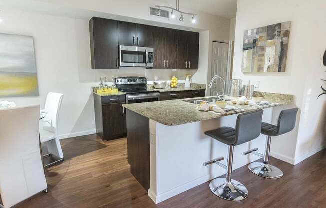 A kitchen with a bar stool and a counter.
