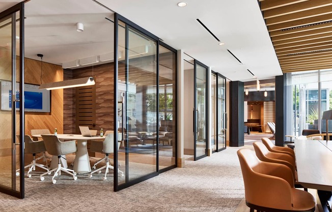 a conference room with glass walls and a table with chairs