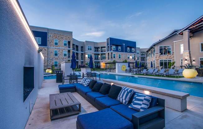 a swimming pool with blue couches and a table