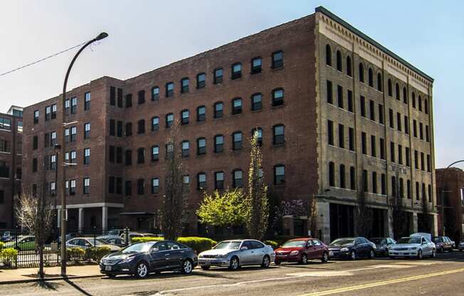 a large brick building on a city street with cars parked