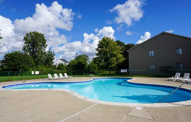 Swimming Pool and pool chairs with apartment in background, at Garfield Commons