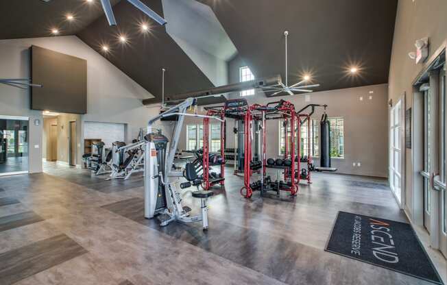 a spacious fitness center with exercise equipment and a large screen on the wall
