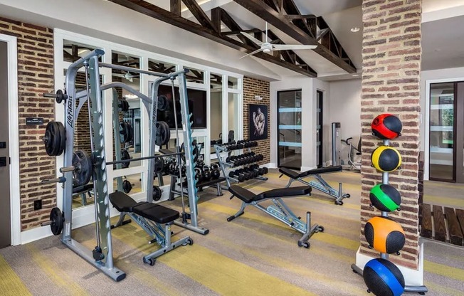 A home gym with a variety of equipment including a squat rack, bench, and weights.