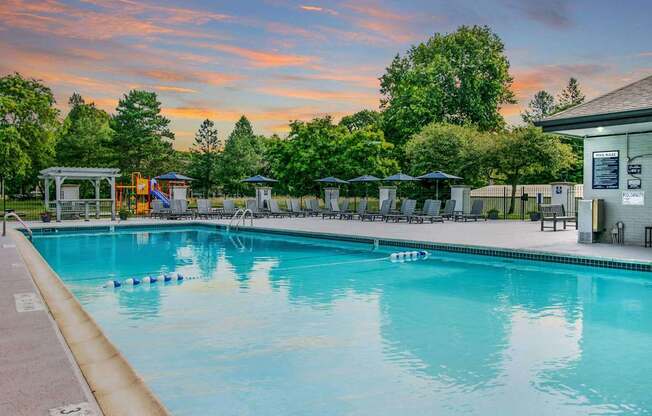 A large swimming pool with a sunset in the background.