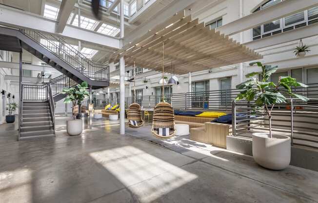 the lobby of an office building with stairs and plants at Highland Mill Lofts, Charlotte, NC