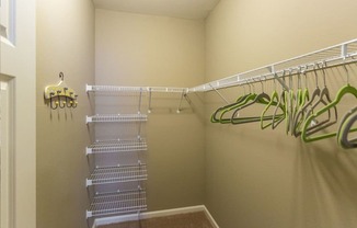 a walk in closet with shelves and a mirrored closet door