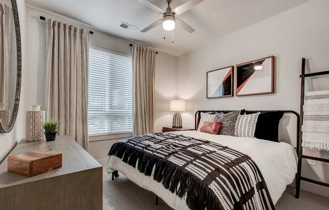 our apartments offer a bedroom with a large bed and a ceiling fan