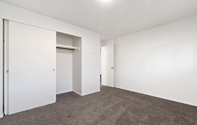 an empty living room with carpet and white walls