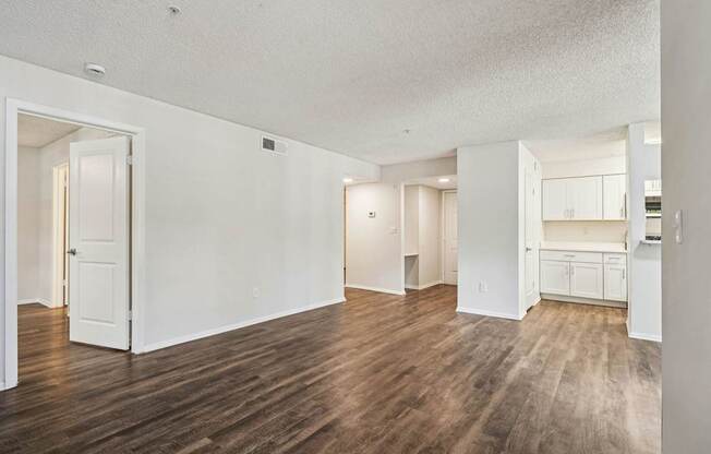 A spacious room with wooden floors and white walls.