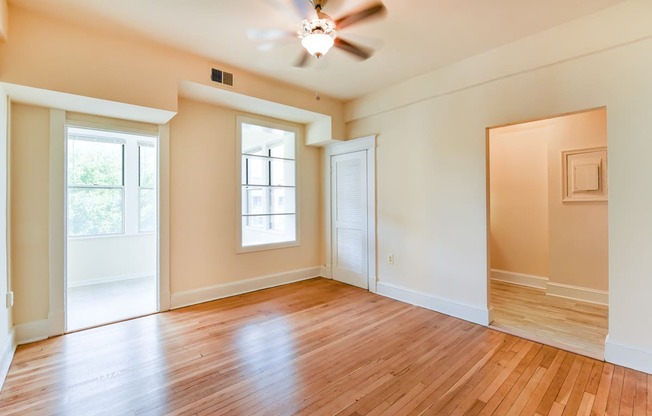 vacant living area with hardwood flooring, large windows and ceiling fan at twin oaks apartments columbia heights washington dc