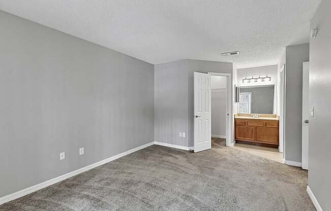 A room with a carpeted floor and a wooden cabinet.